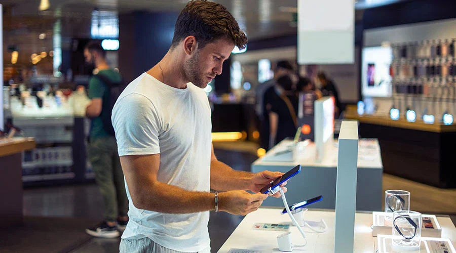 PayMore Rockville staff evaluating a smartphone before purchase.